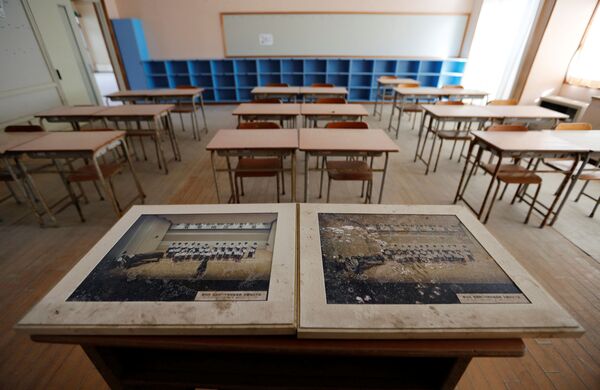 津波の被害を受けた学校の机の上のクラス写真。 - Sputnik 日本