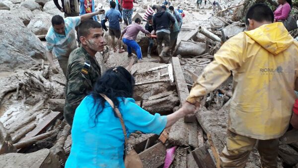 In this handout photo released by the Colombian National Army, soldiers and rescue workers evacuate residents from the area in Mocoa, Colombia, Saturday, April 1, 2017, after an avalanche of water from an overflowing river swept through the city as people slept. - Sputnik 日本