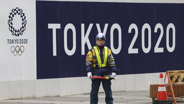 A security guard stands in front of an official logo of the 2020 Tokyo Olympic Games on the safety wall at a construction site in Tokyo's Nihonbashi shopping and office district, Monday, Feb. 6, 2017 - Sputnik 日本
