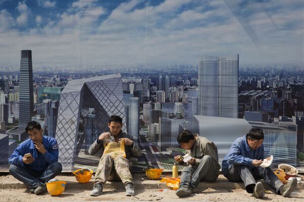北京の建設現場のバナーのそばで休憩する建設作業員 - Sputnik 日本