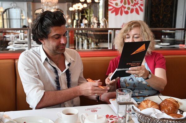 バレエダンサーのニコライ・ツィスカリーゼ氏がスプートニクの読者用に、ブロックノートにサインをしている - Sputnik 日本