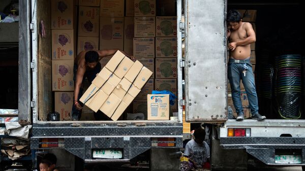 Дети отдыхают под разгружаемым грузовиком, Манила - Sputnik 日本