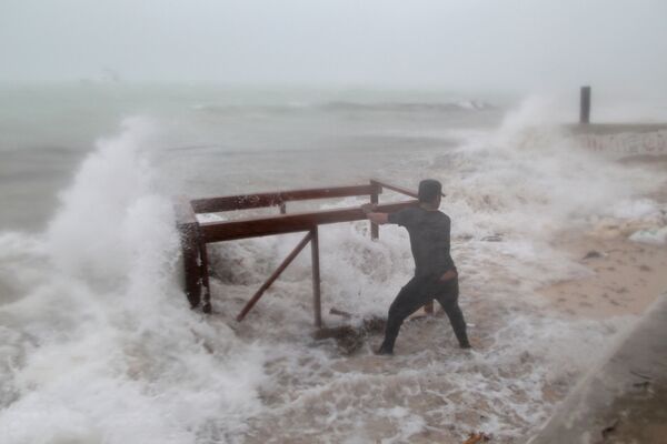 ハリケーン「マリア」の直撃で、海にに流されたレストランのテーブルを引き揚げようとする男性。ドミニカ共和国、プンタカナ - Sputnik 日本