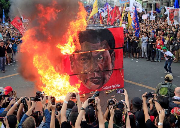 フィリピンのマニラで、ロドリゴ・ドゥテルテ大統領の写真に火を付けるデモ参加者 - Sputnik 日本