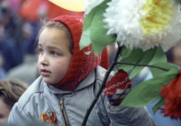 １９８９年の第７２回十月社会主義者大革命を記念した赤の広場での労働者のデモンストレーションに花を持って参加する少女 Великой Октябрьской социалистической революции, 1989 год - Sputnik 日本