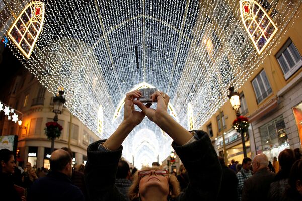 スペイン南部マラガのマルケス・デ・ラリオス通りでクリスマスリースの写真を撮る女性 - Sputnik 日本