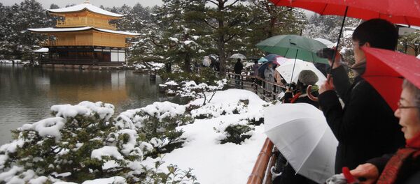 Tourists look at the snow covered Kinkakuji, golden pavilion, at Rokuonji Temple in Kyoto, western Japan on February 14, 2014 Tourists look at the snow covered Kinkakuji, golden pavilion, at Rokuonji Temple in Kyoto, western Japan on February 14, 2014 - Sputnik 日本