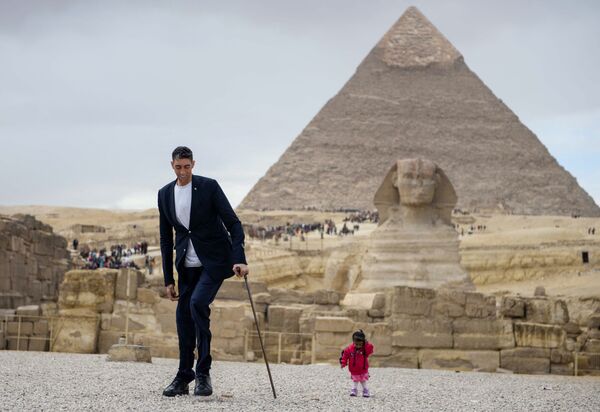 世界一身長の高い人物スルタン・キョセンさんと世界一背が低いインド出身の女性ジョティー・アムゲさん。エジプト・ギザのピラミッドを背景に - Sputnik 日本