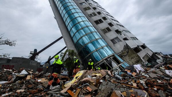 Спасатели выходят из здания Yun Tsui, которое поддерживается подпорками после землетрясения городе Хуалянь, Тайвань - Sputnik 日本