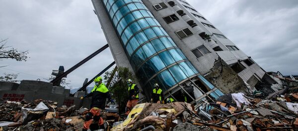 Спасатели выходят из здания Yun Tsui, которое поддерживается подпорками после землетрясения городе Хуалянь, Тайвань - Sputnik 日本