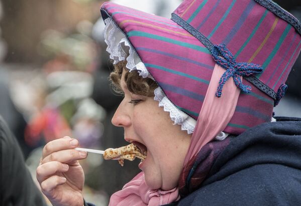 モスクワ・赤の広場でのマースレニツア祭りで「ブリヌィ」を食べる女性 - Sputnik 日本