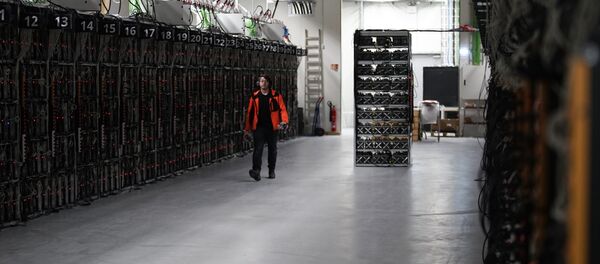 In this photo taken on Jan. 17, 2018, a worker walks along a row of computer rigs that run around the clock 'mining' bitcoin inside the Genesis Mining cryptocurrency mine in Keflavik, Iceland In this photo taken on Jan. 17, 2018, a worker walks along a row of computer rigs that run around the clock 'mining' bitcoin inside the Genesis Mining cryptocurrency mine in Keflavik, Iceland - Sputnik 日本