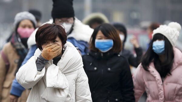A woman uses her hand to cover her face from pollutants as people walk along a street on a polluted day in Beijing, Tuesday, Dec. 8, 2015. - Sputnik 日本
