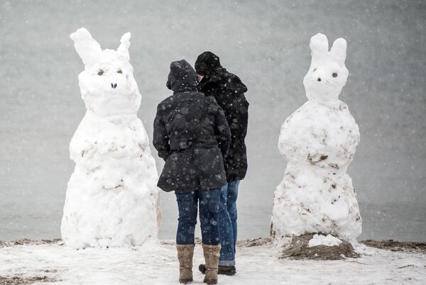 ドイツのフェーマルン島で、ウサギの姿をした２つの雪だるまのそばに立つカップル - Sputnik 日本
