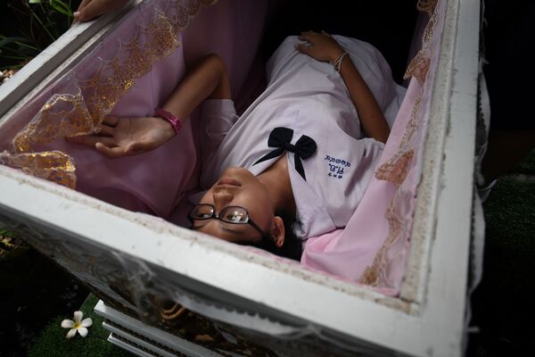 バンコクで開かれた展示スペース「Kid Mai Death Awareness Cafe」にある棺桶に試しに横たわる少女 - Sputnik 日本