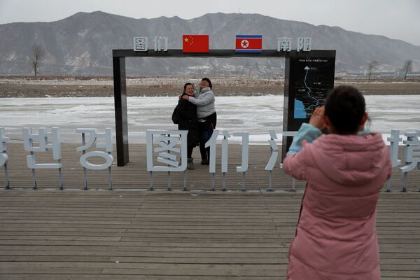 北朝鮮を背景に写真撮影をする観光客たち - Sputnik 日本