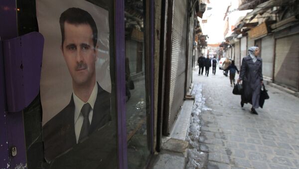 Жительница Дамаска проходит мимо здания с портретом президента Сирии Башара Асада - Sputnik 日本
