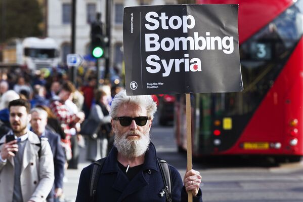 シリア攻撃に反対してロンドンで行われた抗議活動で、シリアを爆撃しないよう求めるプラカードを持つ男性 - Sputnik 日本
