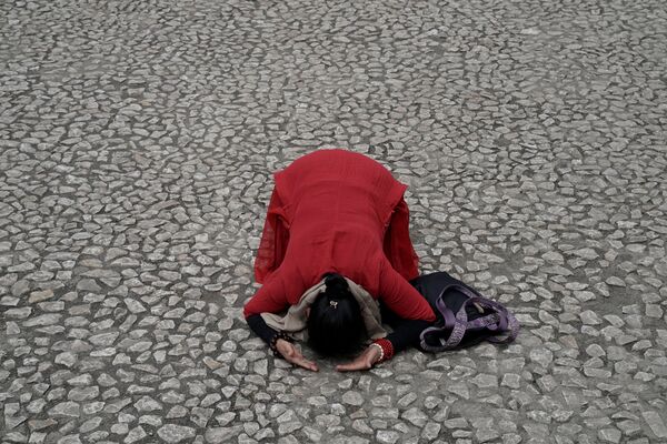 ２００８年の地震時に瓦礫の下で生徒らが亡くなった学校の建物近くで祈る女性 - Sputnik 日本
