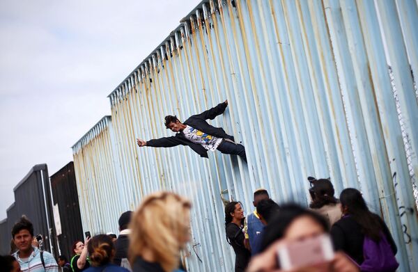 メキシコと米国を分断する壁に登る移民によるデモ参加者 - Sputnik 日本