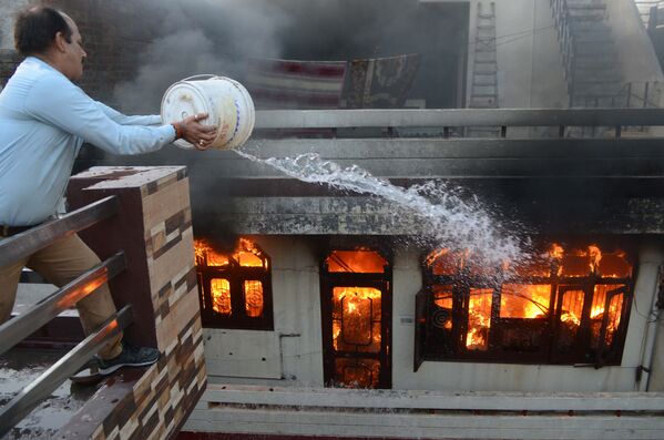 家電販売店で起きた火災を消そうとする男性。インド・アムリトサル - Sputnik 日本