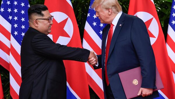 U.S. President Donald Trump and North Korea's leader Kim Jong Un shake hands during the signing of a document after their summit at the Capella Hotel on Sentosa island in Singapore June 12, 2018 - Sputnik 日本