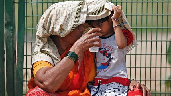 Бабушка дает внучке стакан воды на одной из улиц Нью-Дели, Индия - Sputnik 日本