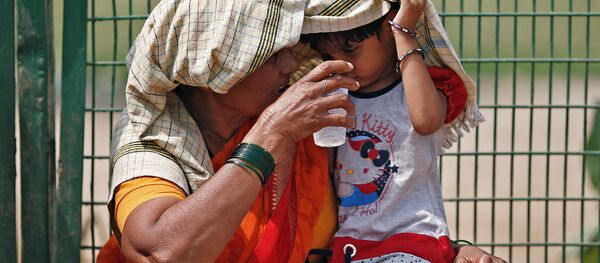Бабушка дает внучке стакан воды на одной из улиц Нью-Дели, Индия Бабушка дает внучке стакан воды на одной из улиц Нью-Дели, Индия - Sputnik 日本