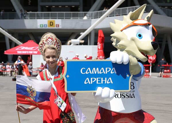 サッカーＷ杯ロシア大会の公式マスコット、オオカミの「ザビワカ」と写真を撮ってもらう少女 - Sputnik 日本