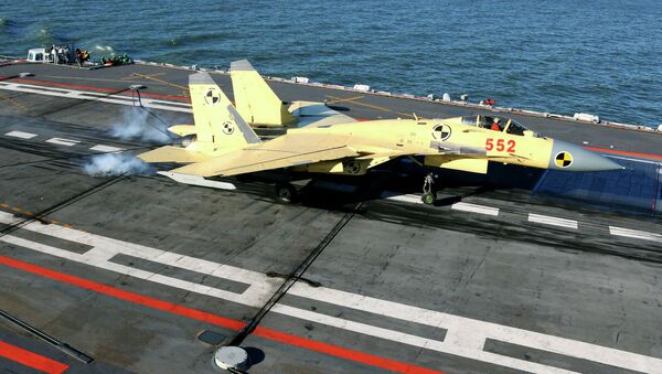 In this undated photo released by China's Xinhua News Agency, a carrier-borne J-15 fighter jet lands on China's first aircraft carrier, the Liaoning - Sputnik 日本