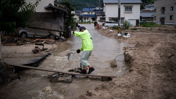 2018年7月8日、広島県坂町で男性が洪水の中帰宅する様子 - Sputnik 日本
