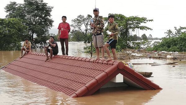 Селяне спасаются от наводнения, вызванного прорывом дамбы, на крыше дома в юго-восточной лаосской провинции Аттапы - Sputnik 日本