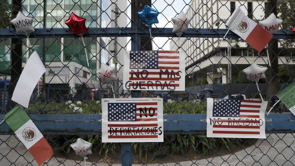 Signs that read in Spanish No more wars, No more deportations and No racism. hang from a fence in front of the U.S Embassy - Sputnik 日本