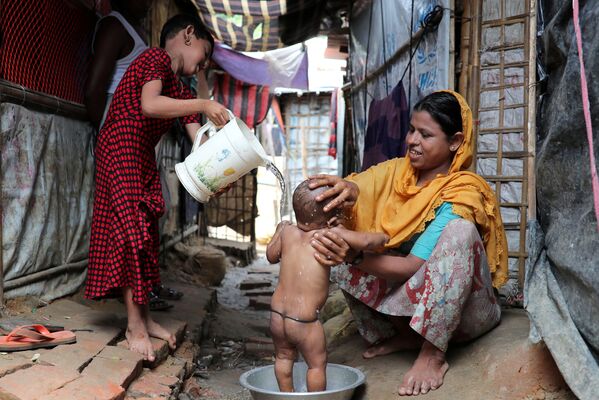 バングラデシュの難民キャンプで、我が子の体を洗うロヒンギャの女性 - Sputnik 日本