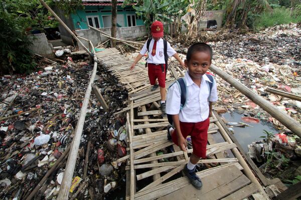 ゴミでいっぱいの川を渡る小学生　インドネシア - Sputnik 日本