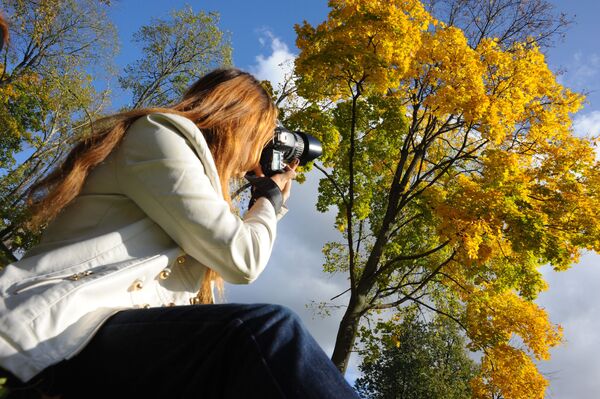 黄色に色づいた木を撮影する女性 - Sputnik 日本