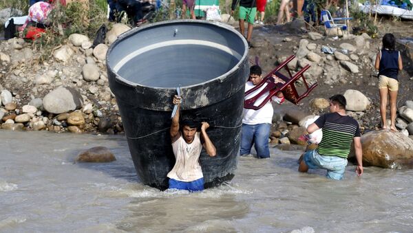 Люди несут свои вещи через реку на границе Венесуэлы и Колумбии - Sputnik 日本