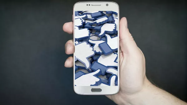El símbolo de 'me gusta' de Facebook en una pantalla de celular - Sputnik 日本
