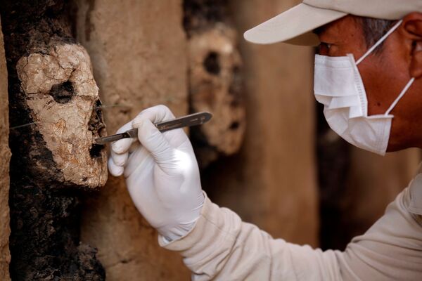 木製の仮面をクリーニングする考古学者 - Sputnik 日本