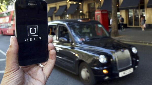 A photo illustration shows the Uber app logo displayed on a mobile telephone, as it is held up for a posed photograph in central London, Britain August 17, 2016. - Sputnik 日本