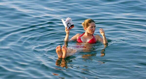 死海での海水浴中に読書する女性 - Sputnik 日本