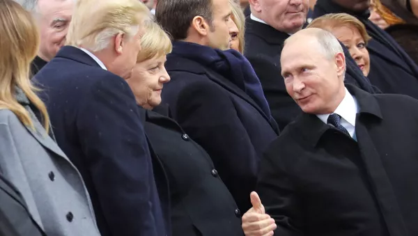 Russian President Vladimir Putin talks with German Chancellor Angela Merkel and US President Donald Trump as they attend a ceremony at the Arc de Triomphe in Paris, as part of commemorations marking the 100th anniversary of the 11 November 1918 armistice, ending World War I, Sunday, Nov. 11, 2018.