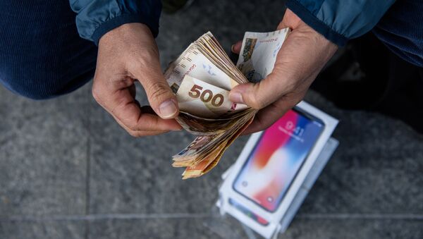 Перекупщик подсчитывает наличные, полученные за продажу iPhone X, около магазина Apple в Гонконге - Sputnik 日本