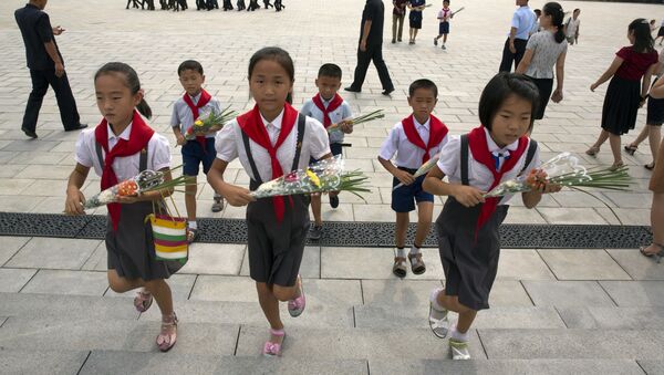 Школьники несут цветы к памятникам северокорейским лидерам Ким Ир Сена и Ким Чен Ира в Пхеньяне в годовщину окончания Второй мировой войны и освобождения от японского колониального правления  - Sputnik 日本