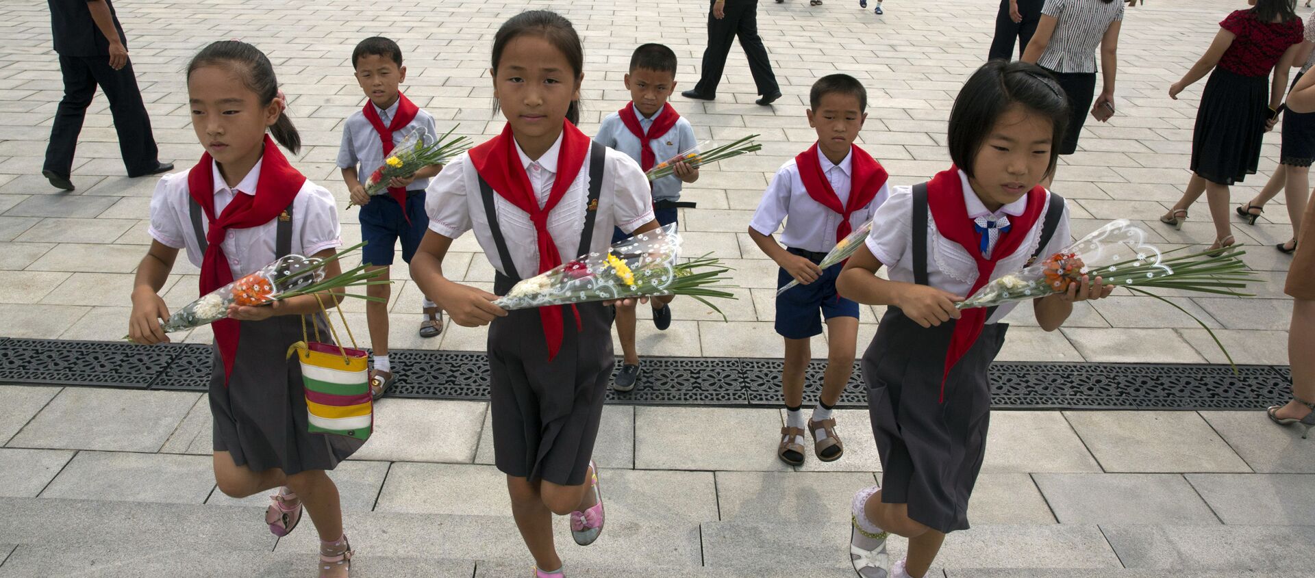 Школьники несут цветы к памятникам северокорейским лидерам Ким Ир Сена и Ким Чен Ира в Пхеньяне в годовщину окончания Второй мировой войны и освобождения от японского колониального правления  - Sputnik 日本, 1920, 21.01.2021