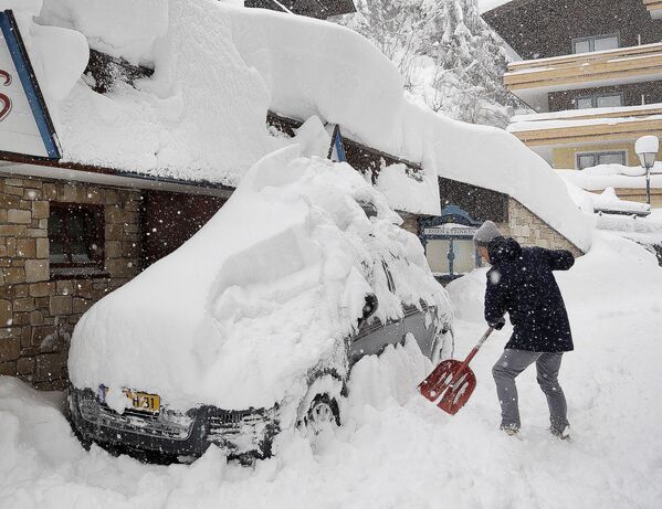 雪に埋もれた車を掘り起こす男性。オーストリア - Sputnik 日本