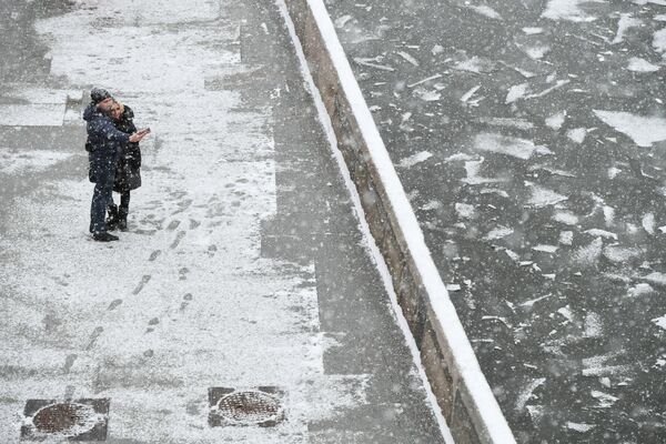 雪が降る中、モスクワ川沿いの通りに佇む若者たち - Sputnik 日本