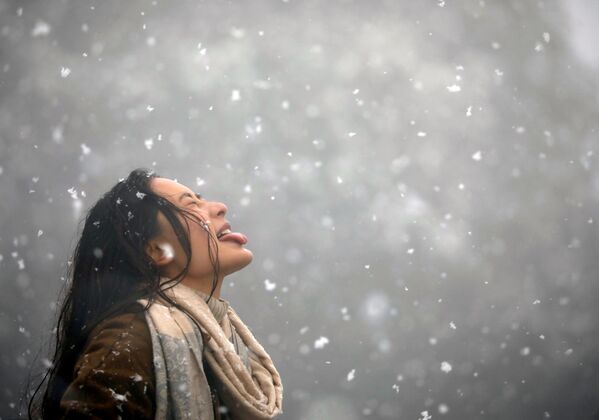 降った雪を口で捕まえる女性。ネパール - Sputnik 日本