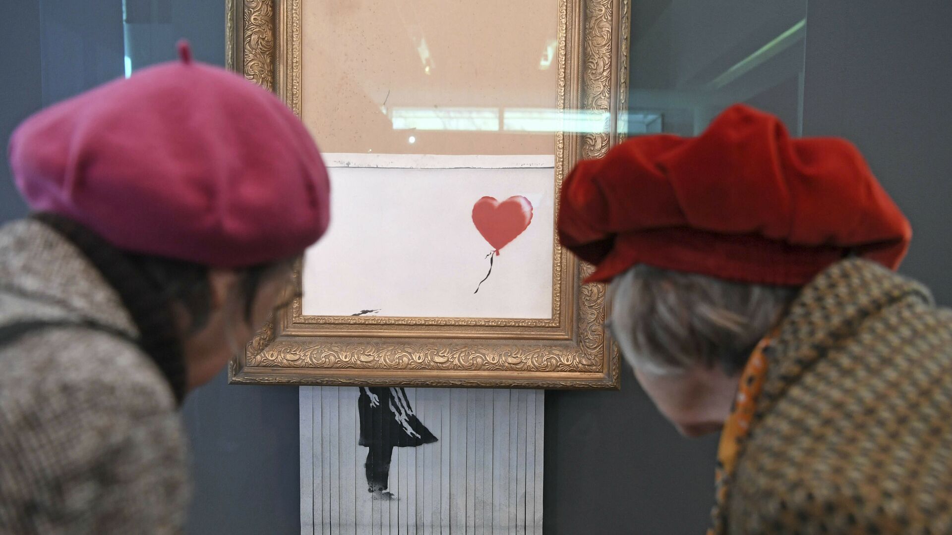 Посетители смотрят на самоуничтожившуюся после продажи на аукционе картину художника Бэнкси Девочка с воздушным шаром, которая теперь называется Любовь в мусорном баке, в Музее современного искусства в Баден-Бадене, Германия - Sputnik 日本, 1920, 15.10.2021