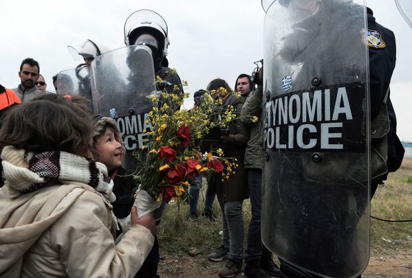 難民キャンプ付近で起きた衝突後、子どもたちが警官に花を贈る。ギリシャ - Sputnik 日本